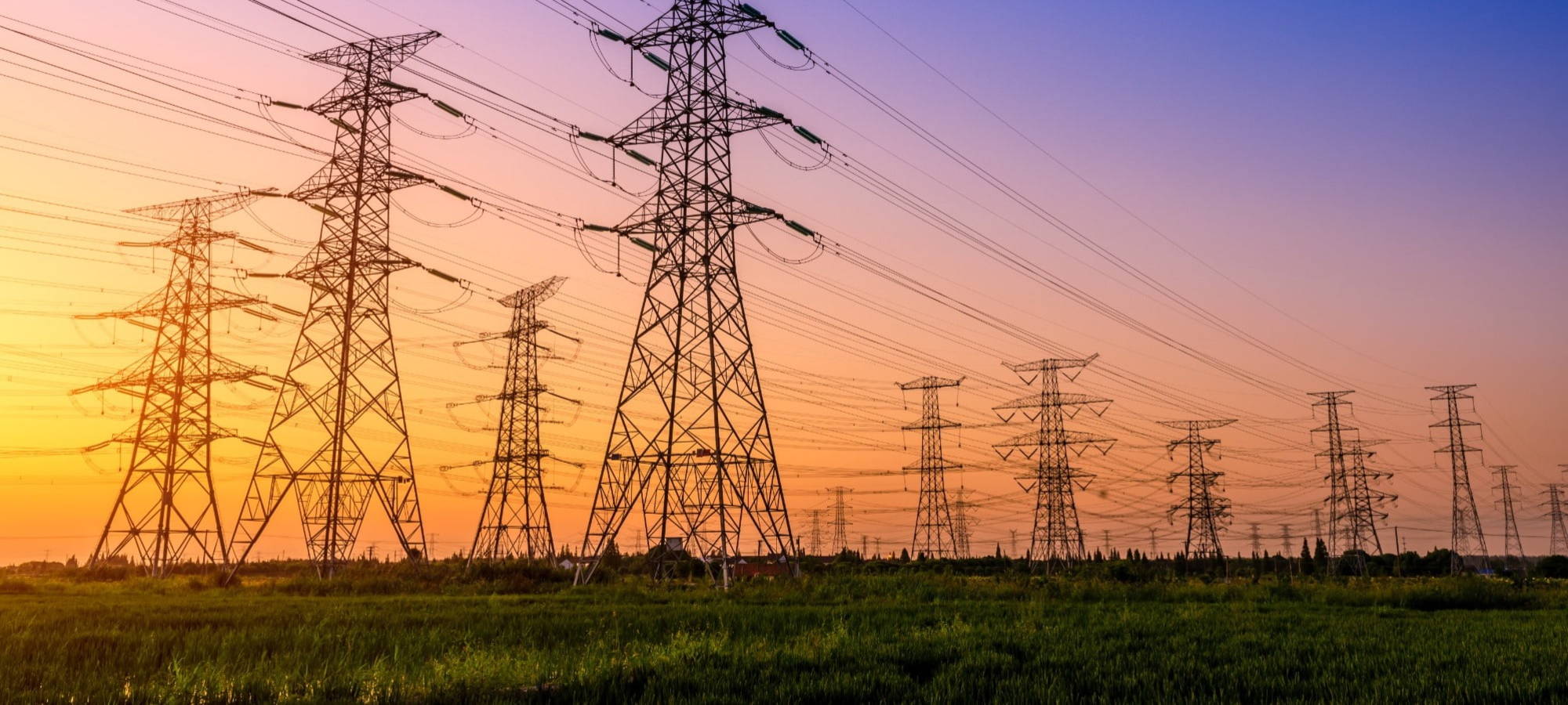 Multiple electricity pylons sunset background ersg
