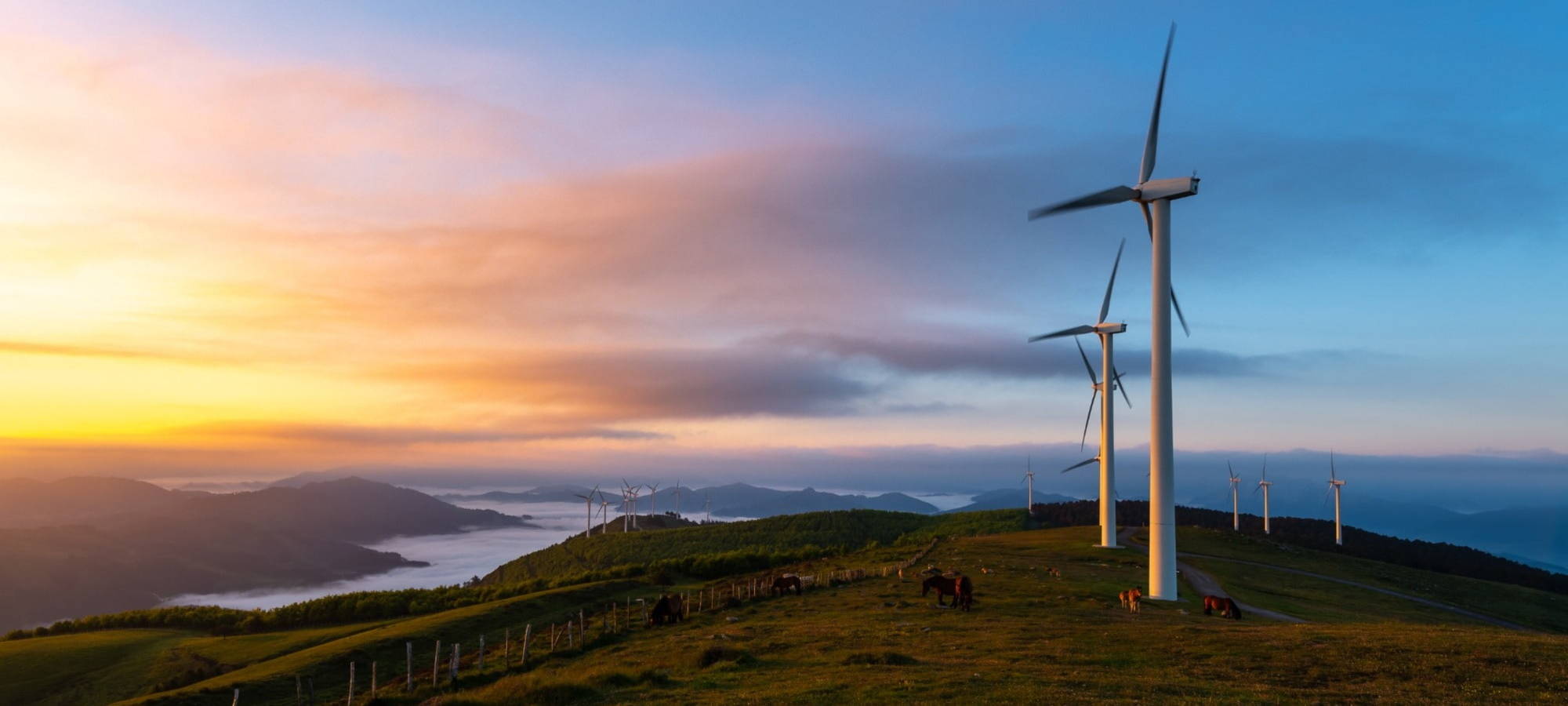 Sunset and windfarm with clouds and mountains in the back ersg