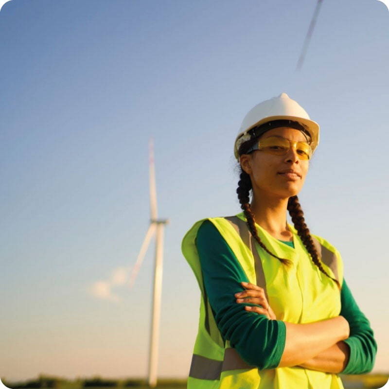 ersg - Renewables energy Rekrutierungsagentur mit einer Dame auf einem Onshore-Windpark in Gesundheits- und Sicherheitskleidung, die ihre Arme verschränkt