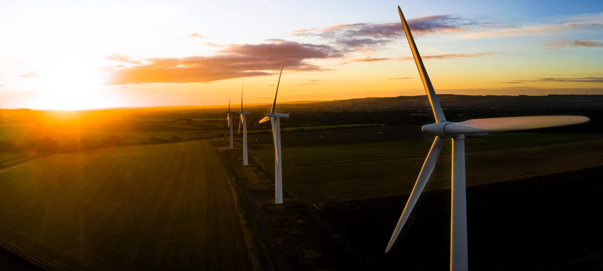 onshore wind farm background with clouds and sunset ersg