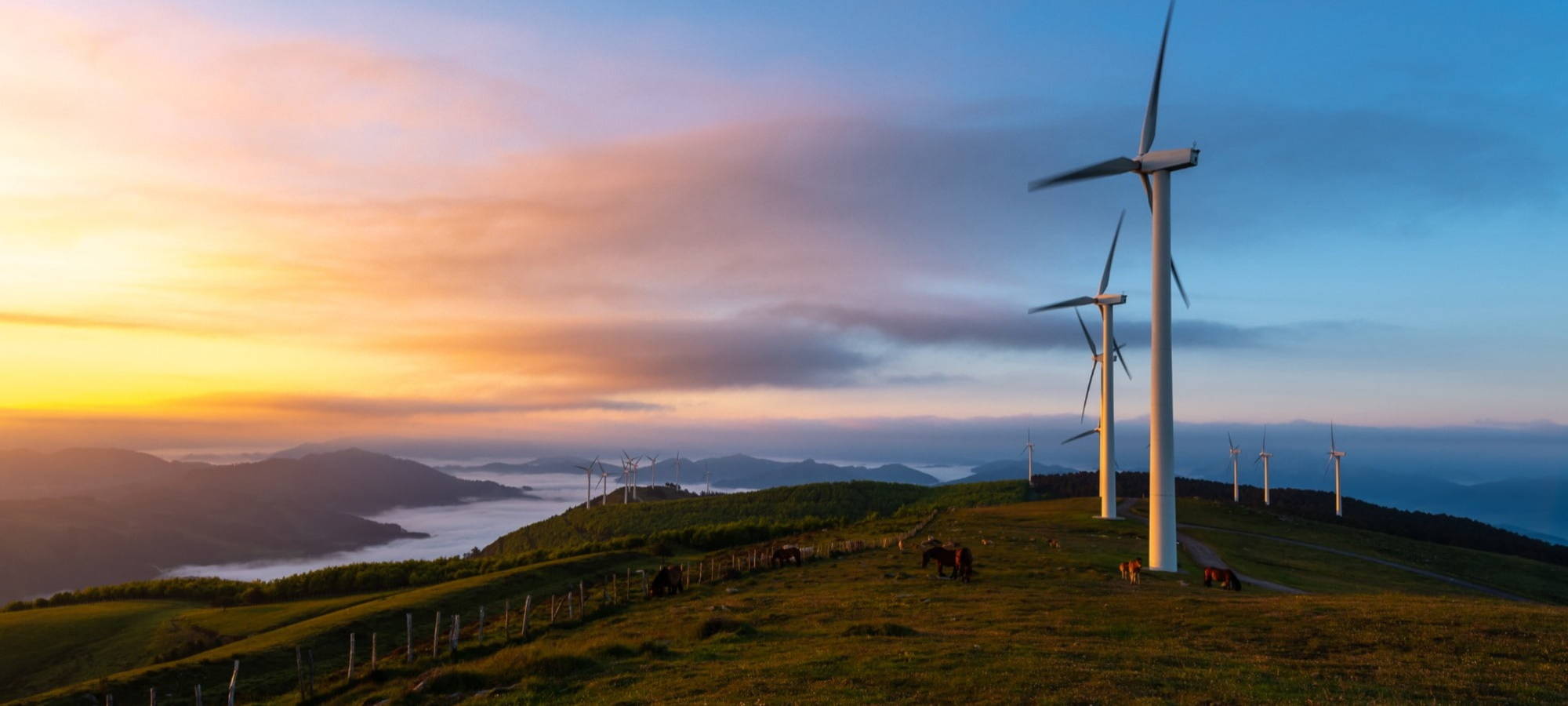 Sunset and windfarm with clouds and mountains in the back ersg